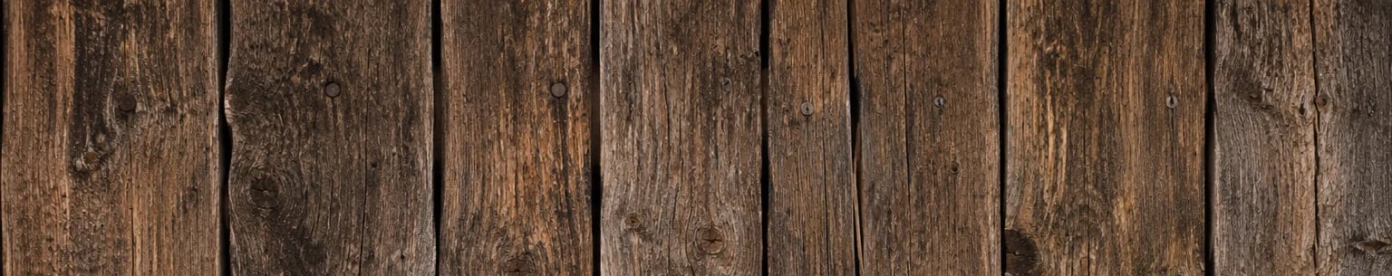 Close-up of aged, weathered wooden planks arranged vertically with visible grain and natural brown tones